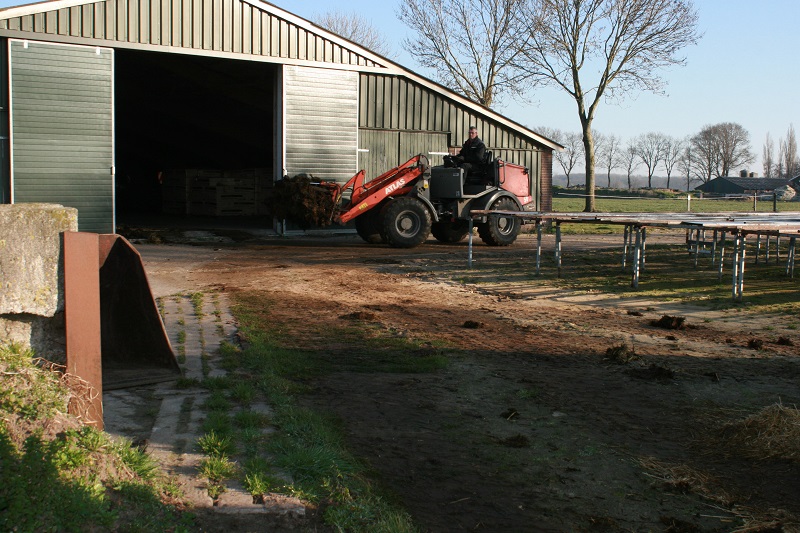 Potstal uitmesten met shovel Atlas met mestvork